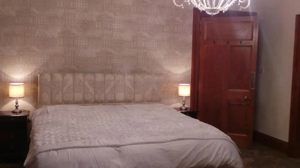 a bedroom with a large bed with two lamps at St Michaels Guest House in Elgin