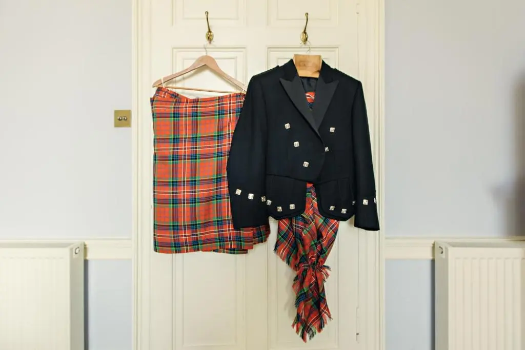 a jacket and a plaid shirt hanging on a door at Dalvey House in Forres
