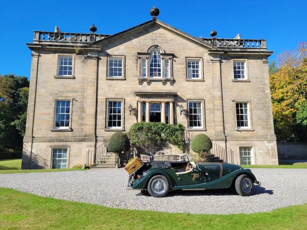 an old green car parked in front of a house at Dalvey House in Forres