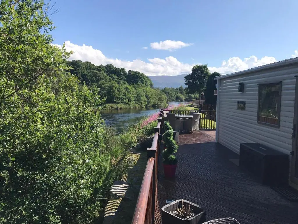 a view of a river from a house at Riverbank Lodge in Aviemore