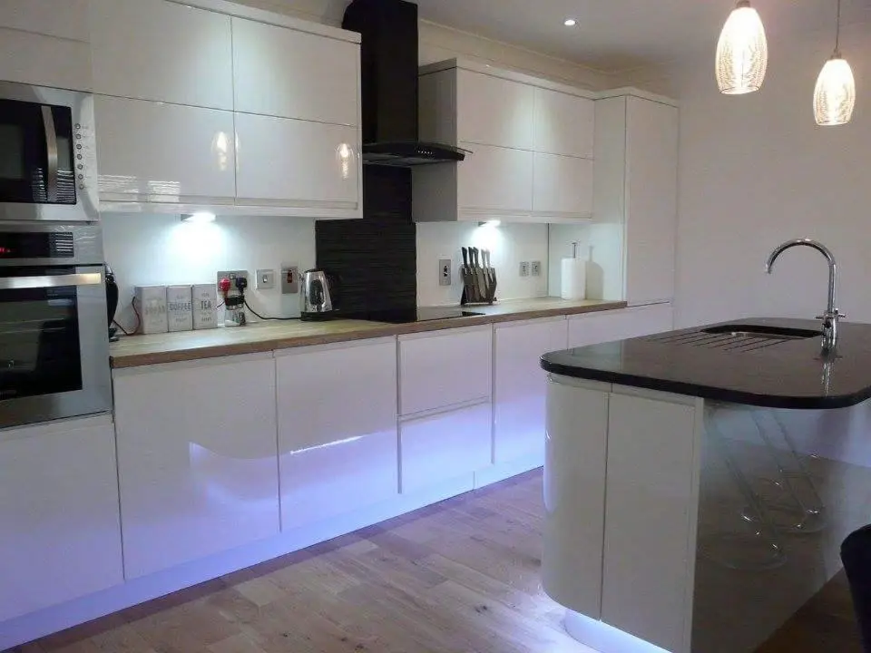 a kitchen with white cabinets and a black counter top at Langley Cottage with patio, spacious rooms - part of Langley Serviced Apartments several properties in Wick in Wick