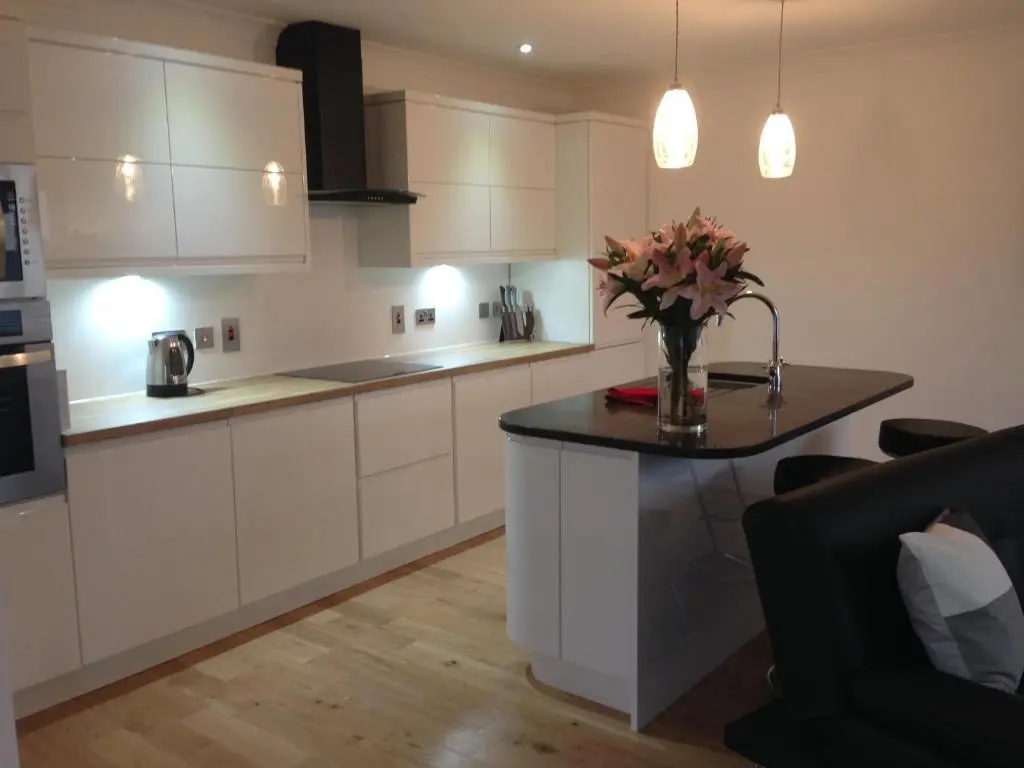 a kitchen with a table with a vase of flowers on it at Langley Cottage with patio, spacious rooms - part of Langley Serviced Apartments several properties in Wick in Wick