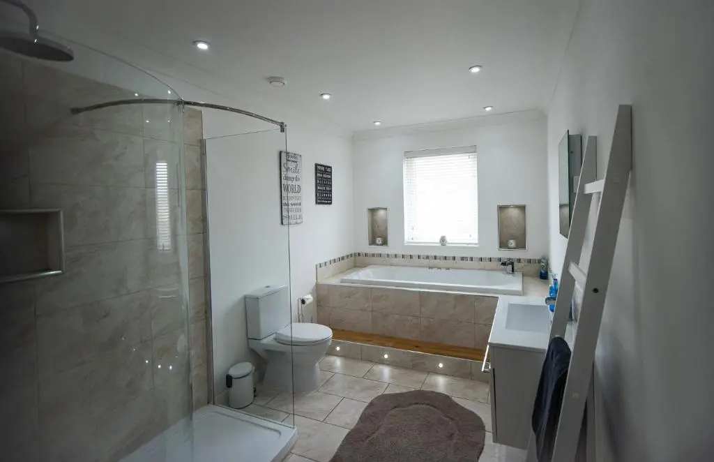 a bathroom with a tub and a toilet and a shower at Langley Cottage with patio, spacious rooms - part of Langley Serviced Apartments several properties in Wick in Wick