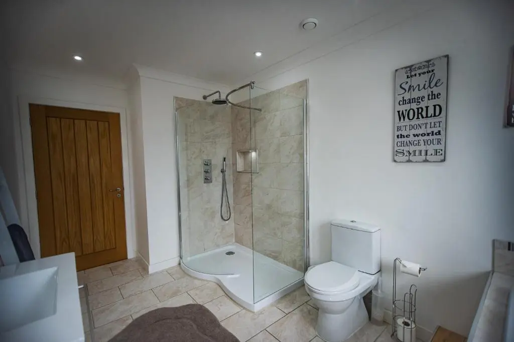 a bathroom with a shower and a toilet in it at Langley Cottage with patio, spacious rooms - part of Langley Serviced Apartments several properties in Wick in Wick