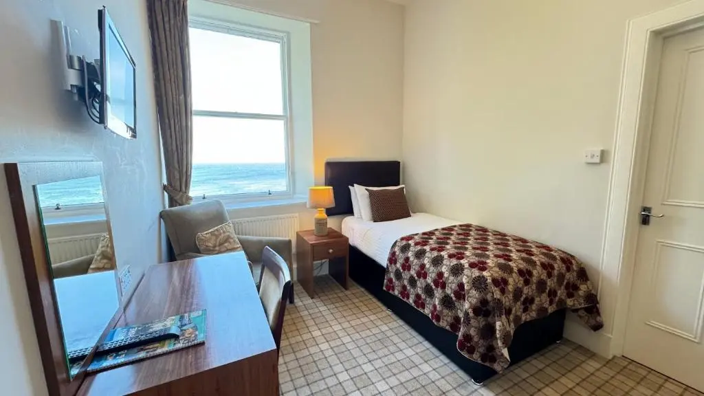 a hotel room with a bed and a window at Invernairne in Nairn