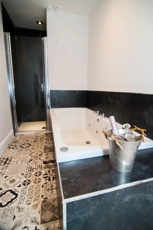 a bathroom with a bath tub and a bucket at Invernairne in Nairn