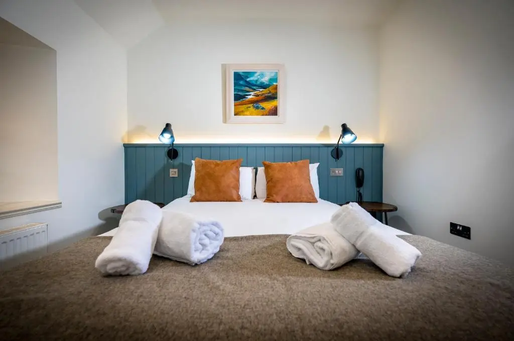 a bedroom with a bed with towels on the floor at Loch Ness Inn in Drumnadrochit