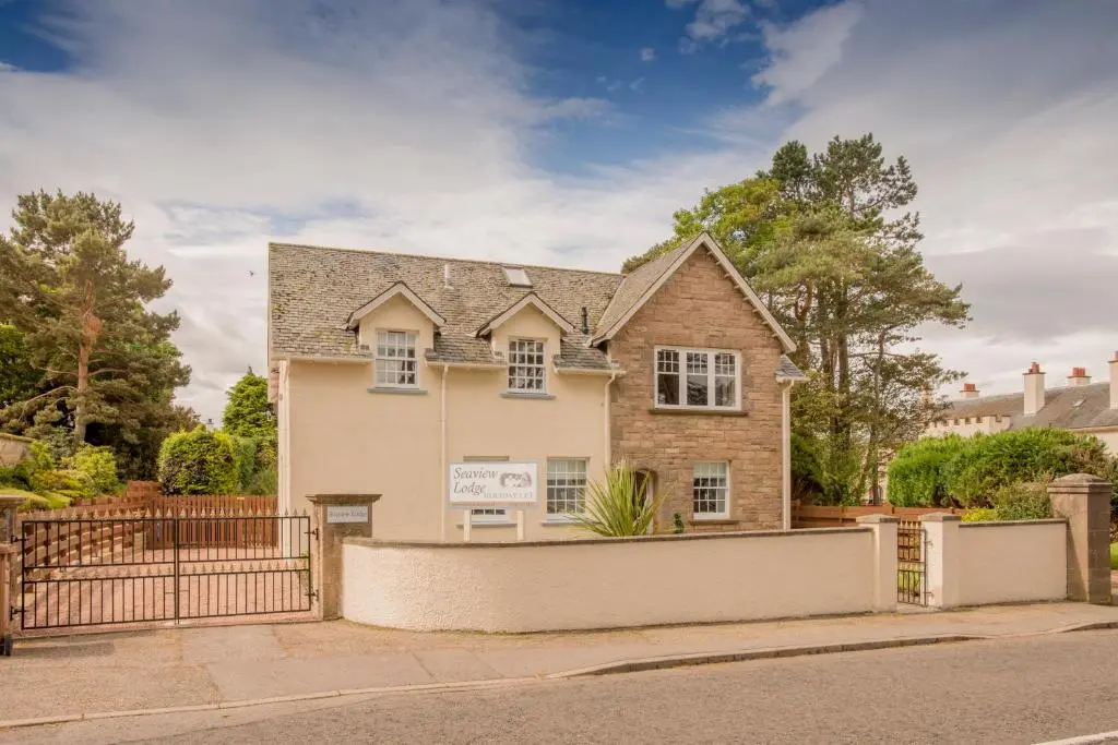 a house with a fence in front of it at Sea View Lodge in Nairn