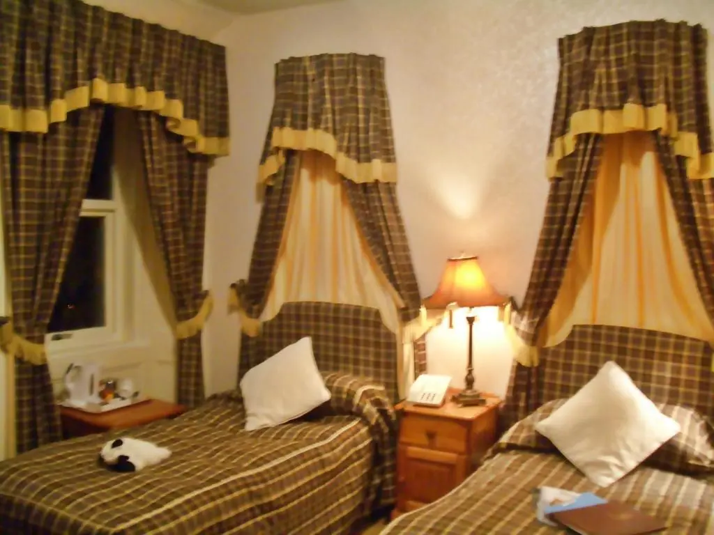 a bedroom with two beds with a stuffed animal on top of them at Atholl Arms in Blair Atholl