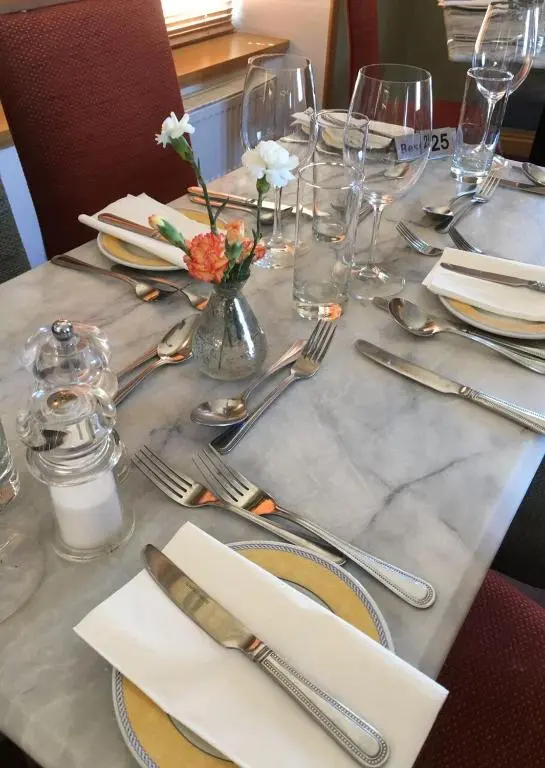 a table set with silverware and flowers on a table at Mackays Hotel in Wick