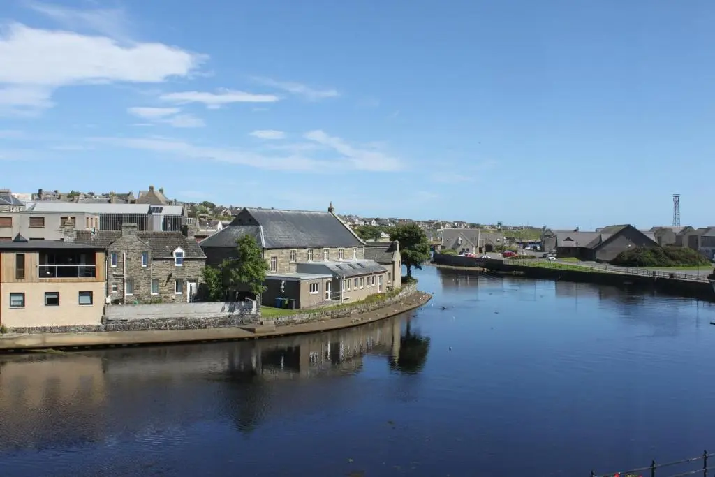 a view of a river with houses and buildings at Mackays Hotel in Wick