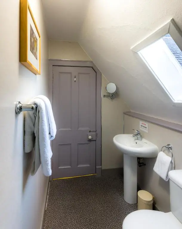 a bathroom with a sink and a toilet and a window at Inch Hotel in Fort Augustus