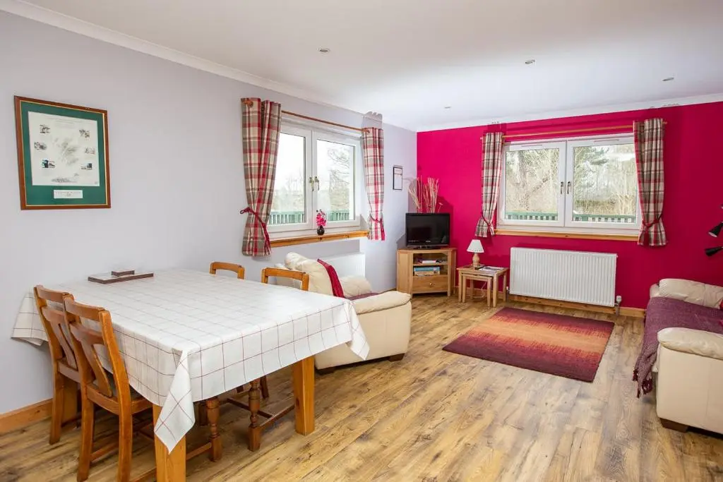 a living room with a table and a couch at Ornum Cottage in Beauly