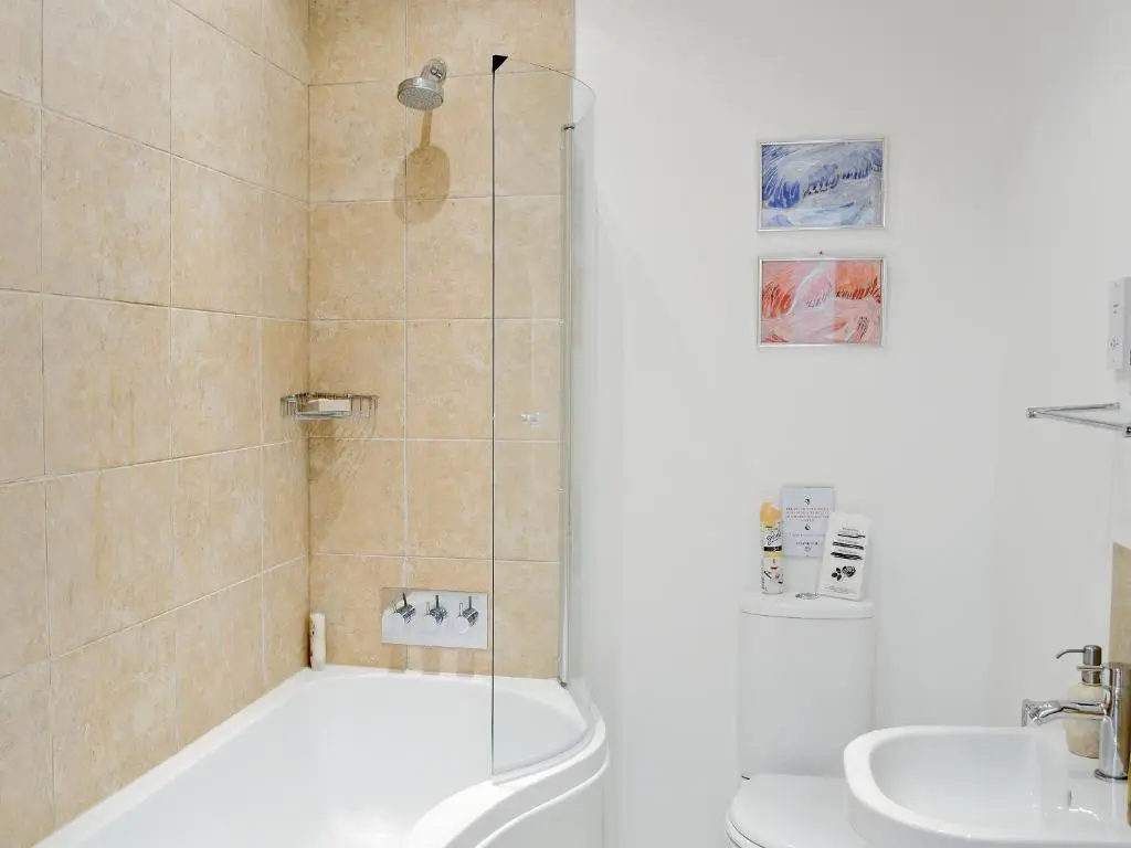 a bathroom with a shower and a toilet and a sink at The Old Granary in Ballindalloch