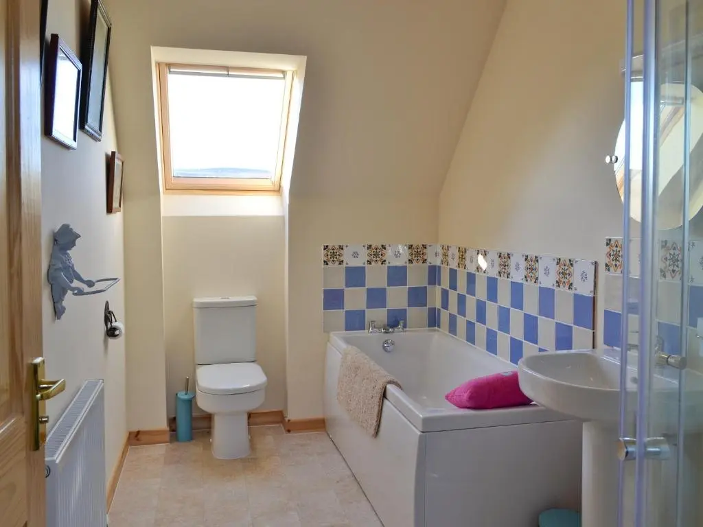 a bathroom with a toilet and a tub and a sink at Mountain View in Tomintoul