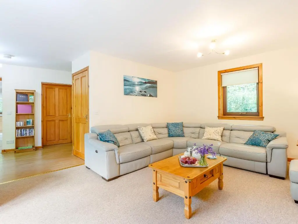 a living room with a couch and a coffee table at Glen View Of Enrick House in Bearnock