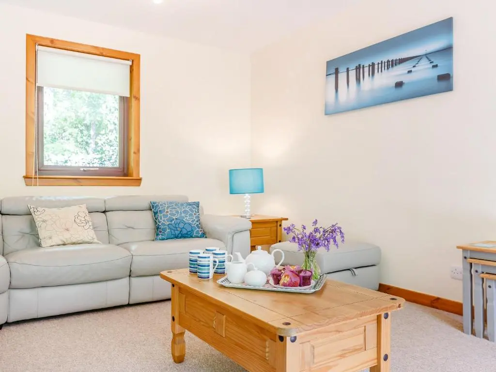 a living room with a couch and a coffee table at Glen View Of Enrick House in Bearnock