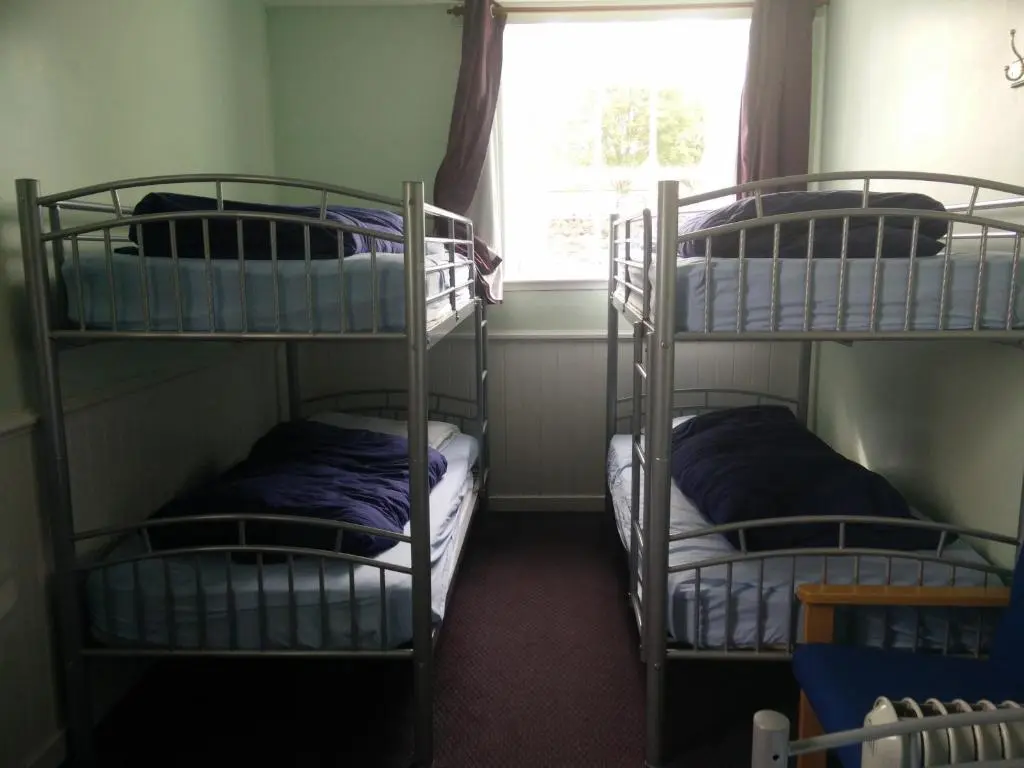 two bunk beds in a room with a window at The Smugglers Hostel in Tomintoul