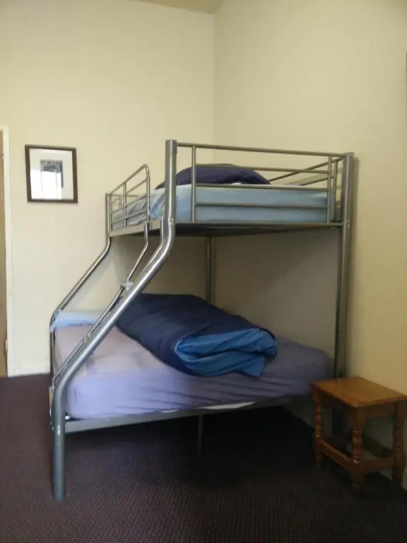 two bunk beds in a room with a table at The Smugglers Hostel in Tomintoul