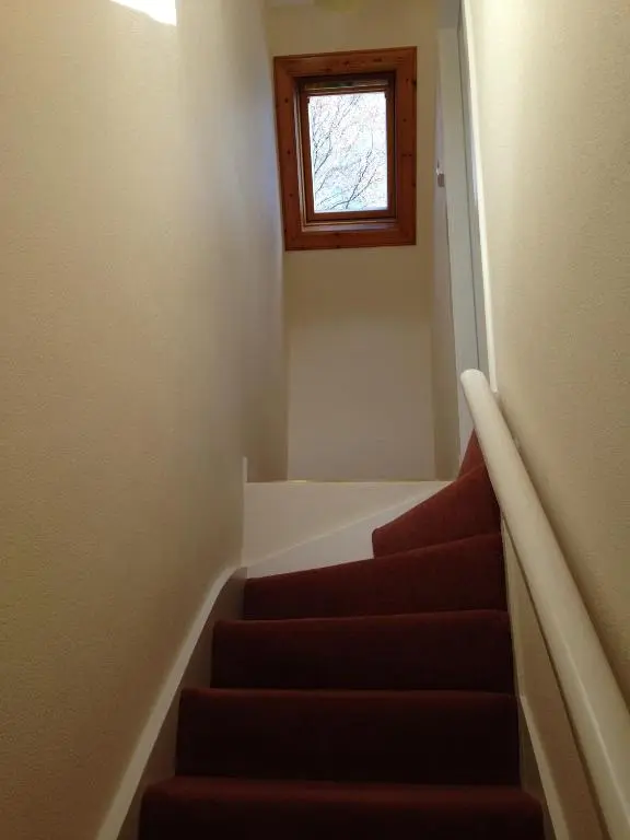 a stairway with a window and a stair case at Eastwood Cottage in Turriff