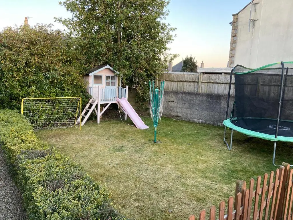 a small yard with a playground with a swing at Ivy Cottage-Serviced accommodation in Dyce