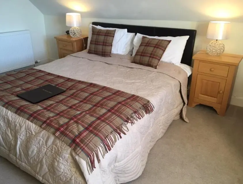 a bedroom with a bed with a laptop on it at The Royal Hotel Cromarty in Cromarty