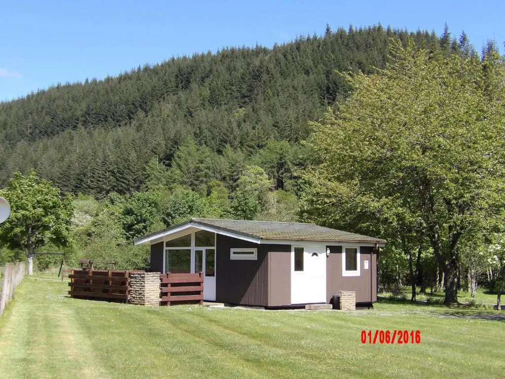 a small shed in the middle of a field at Forest Glen Holiday Park in Invermoriston