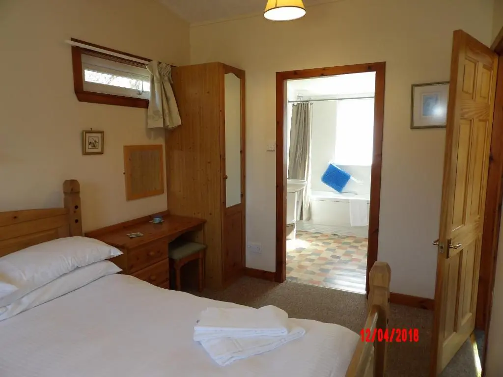 a bedroom with a bed and a room with a window at Forest Glen Holiday Park in Invermoriston