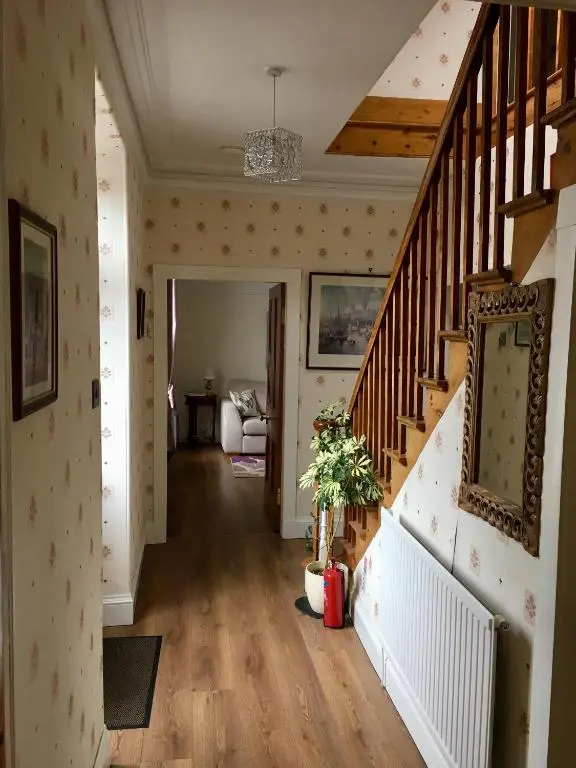 a hallway with a staircase in a home with a stair case at Inveravon Holiday Home in Dufftown