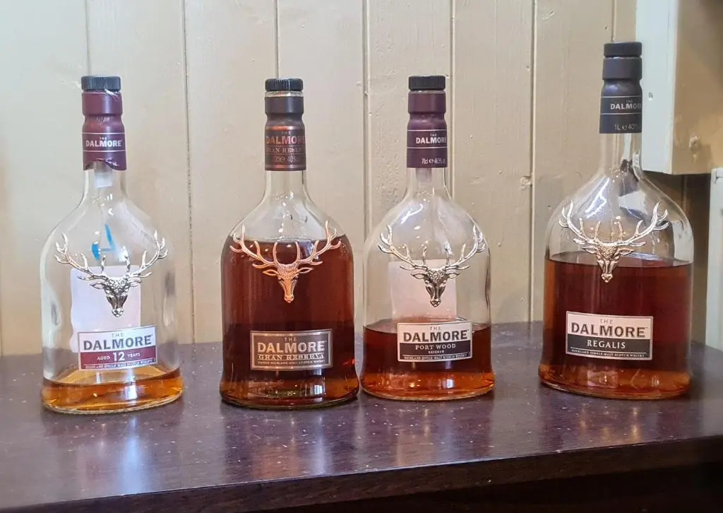 four bottles of whiskey sitting on a table at Victoria Hotel in Portknockie