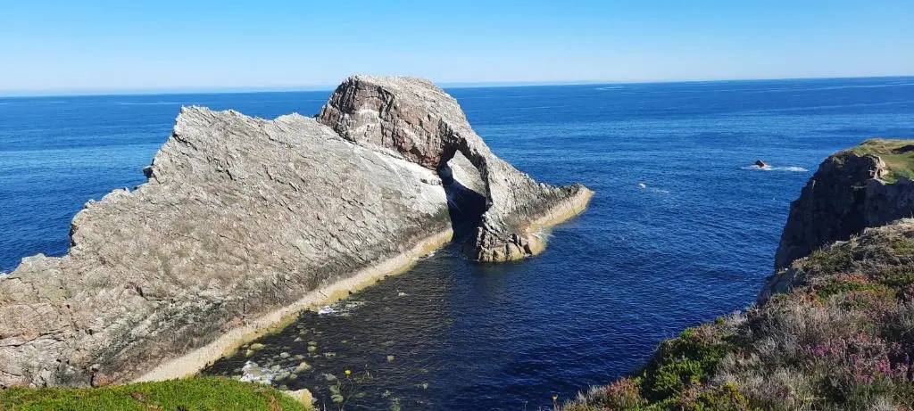 a large rock formation in the water near the ocean at Victoria Hotel in Portknockie