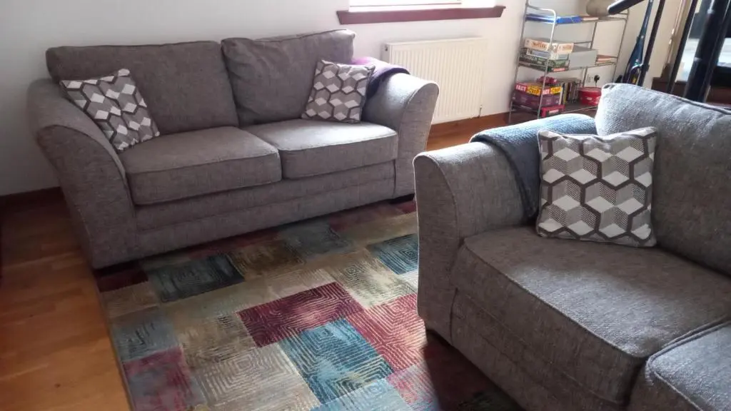 a living room with a couch and a chair at North End The Cottage in Nairn