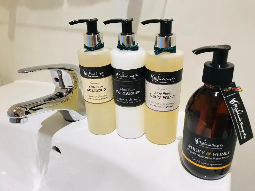 a group of three shampoo bottles sitting on a sink at Lairds Lodge Inverness in Inverness