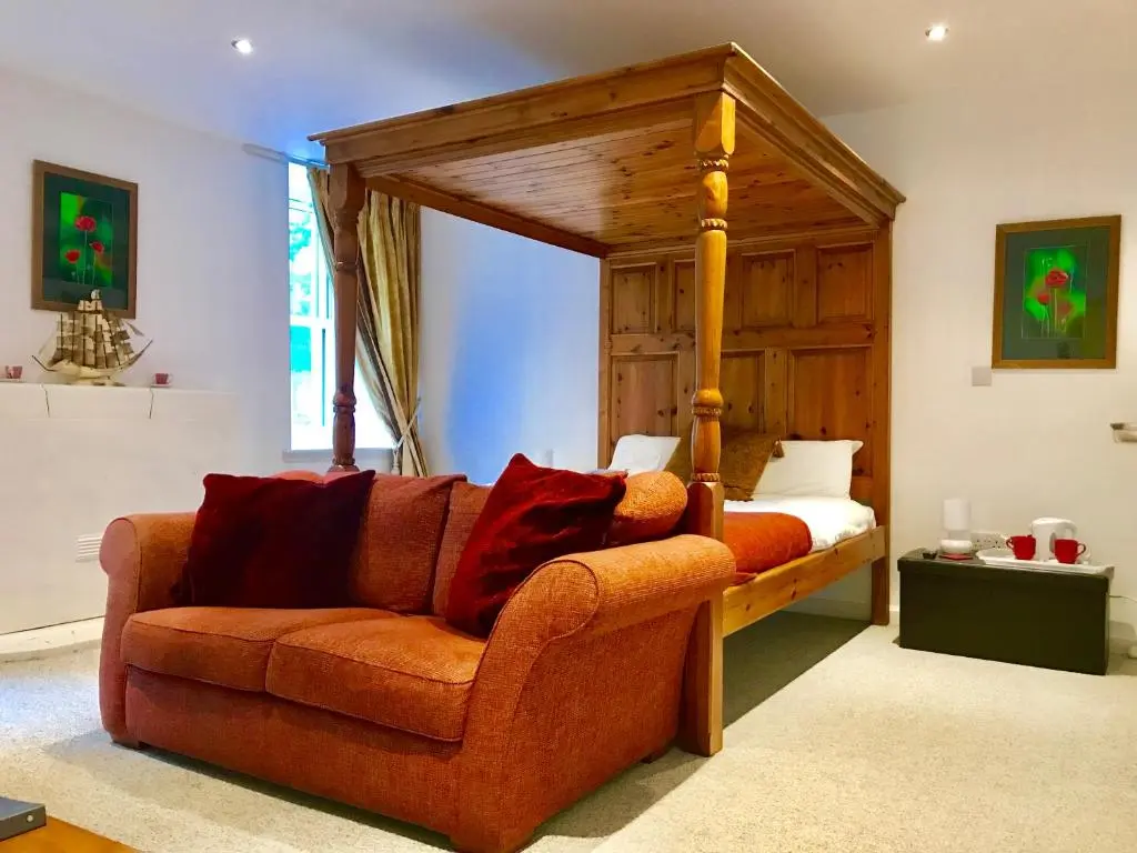 a living room with a couch and a canopy bed at Drumdevan Country House in Inverness