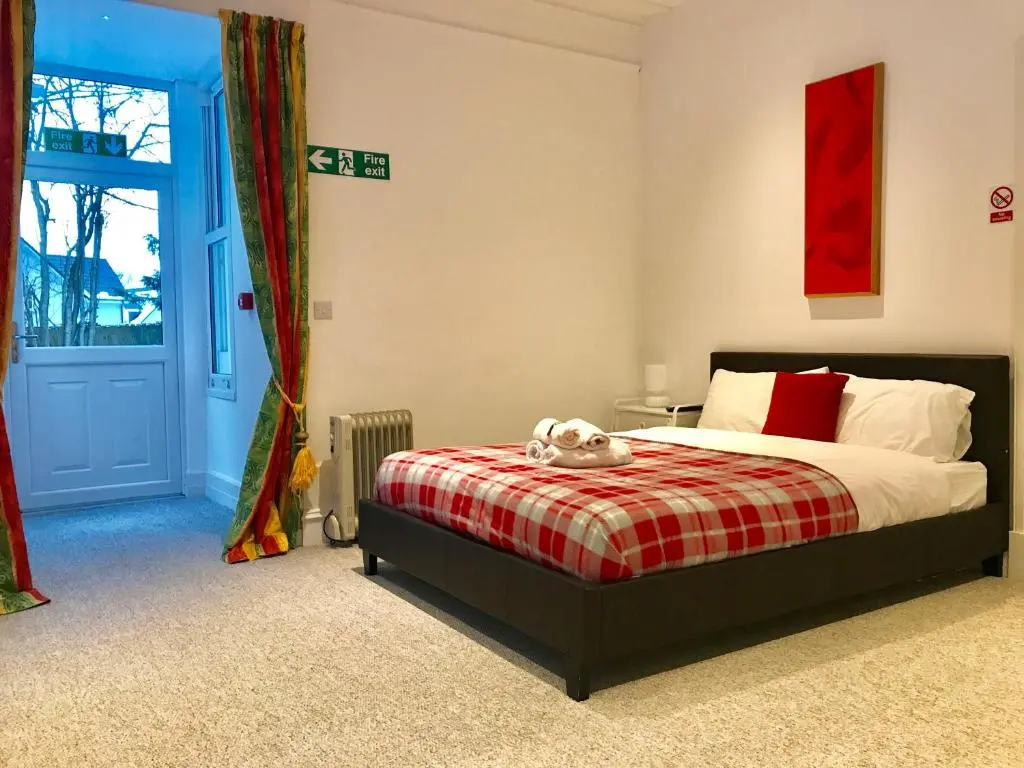 a bedroom with a bed with a teddy bear on it at Drumdevan Country House in Inverness