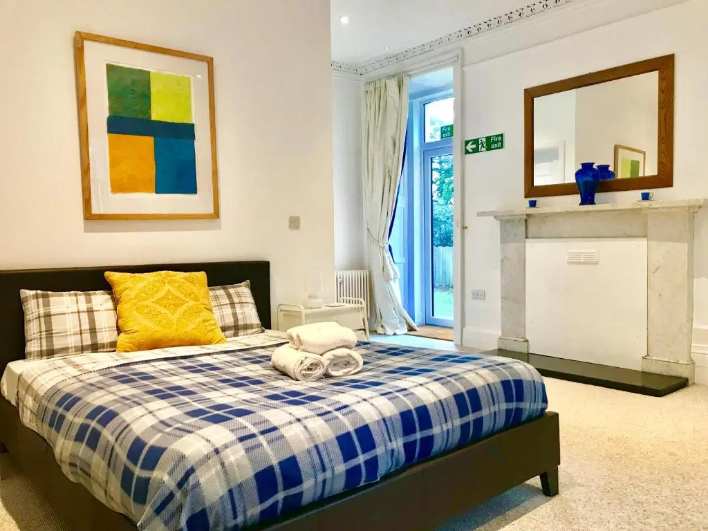 a bedroom with a bed with a blue and white checkered blanket at Drumdevan Country House in Inverness