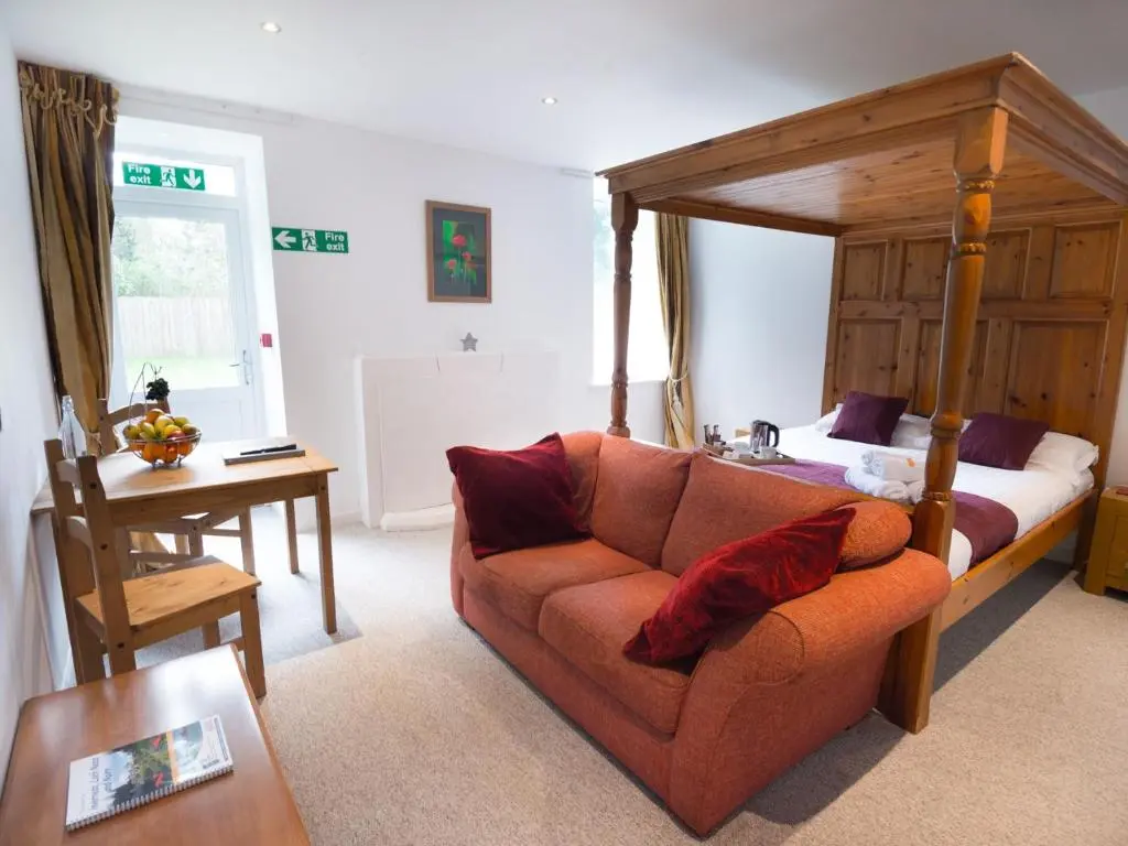 a living room with a couch and a bed at Drumdevan Country House in Inverness