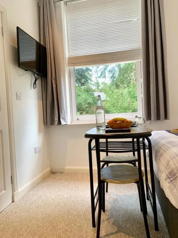a table and a chair in a room with a window at Drumdevan Country House in Inverness