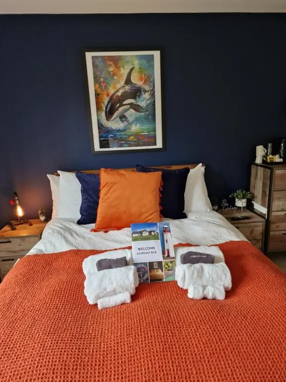 a bedroom with a bed with towels on it at Acarsaid B&B in Lybster