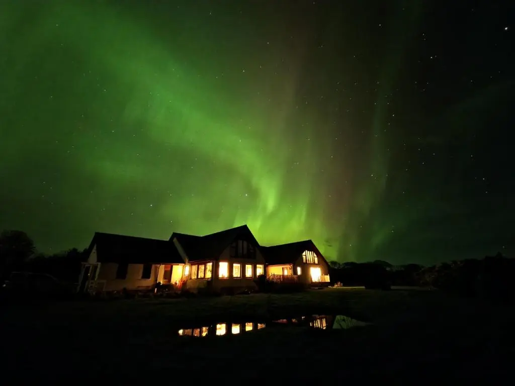 a house with the aurora in the sky at Acarsaid B&B in Lybster