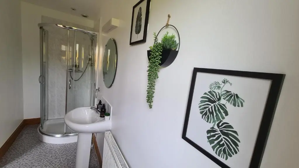 a bathroom with a sink and a toilet and a mirror at Acarsaid B&B in Lybster