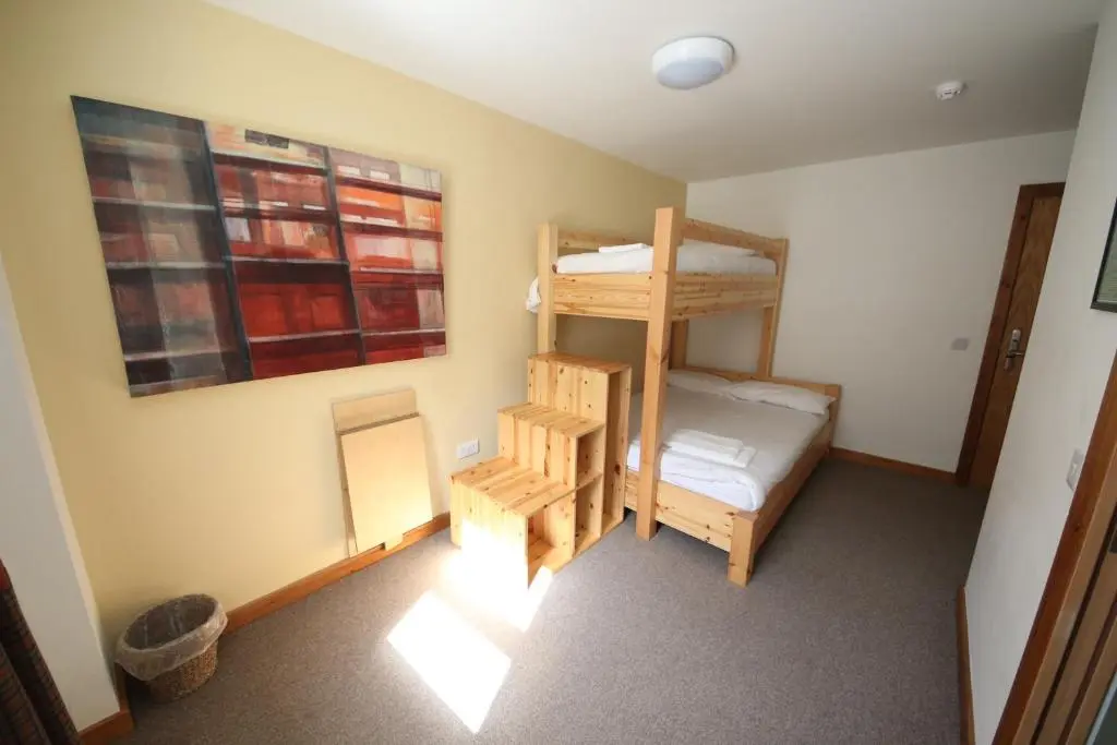 a bedroom with two bunk beds and a ladder at Black Isle Bar & Rooms in Inverness