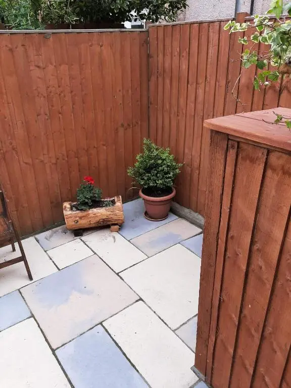 a patio with two potted plants and a wooden fence at Cosy Ness Escape, 16B Ardconnel Street in Inverness