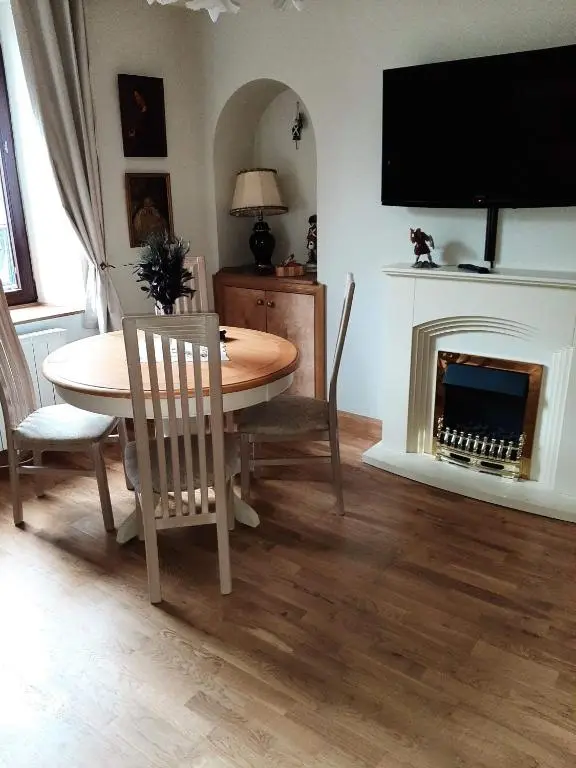 a dining room with a table and a fireplace at Cosy Ness Escape, 16B Ardconnel Street in Inverness