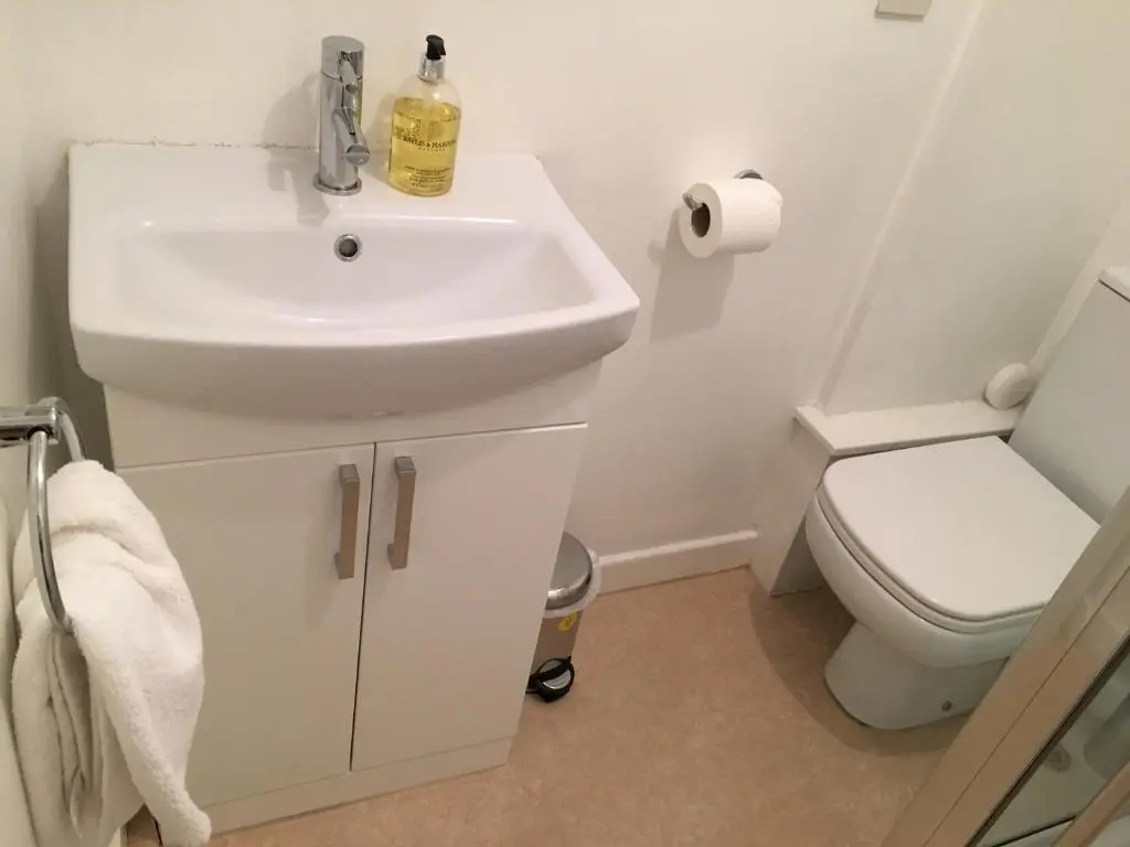 a white bathroom with a sink and a toilet at City Centre Cottage in Inverness