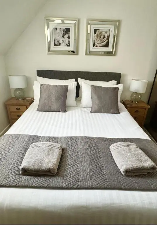 a large white bed with two pillows on it at City Centre Cottage in Inverness