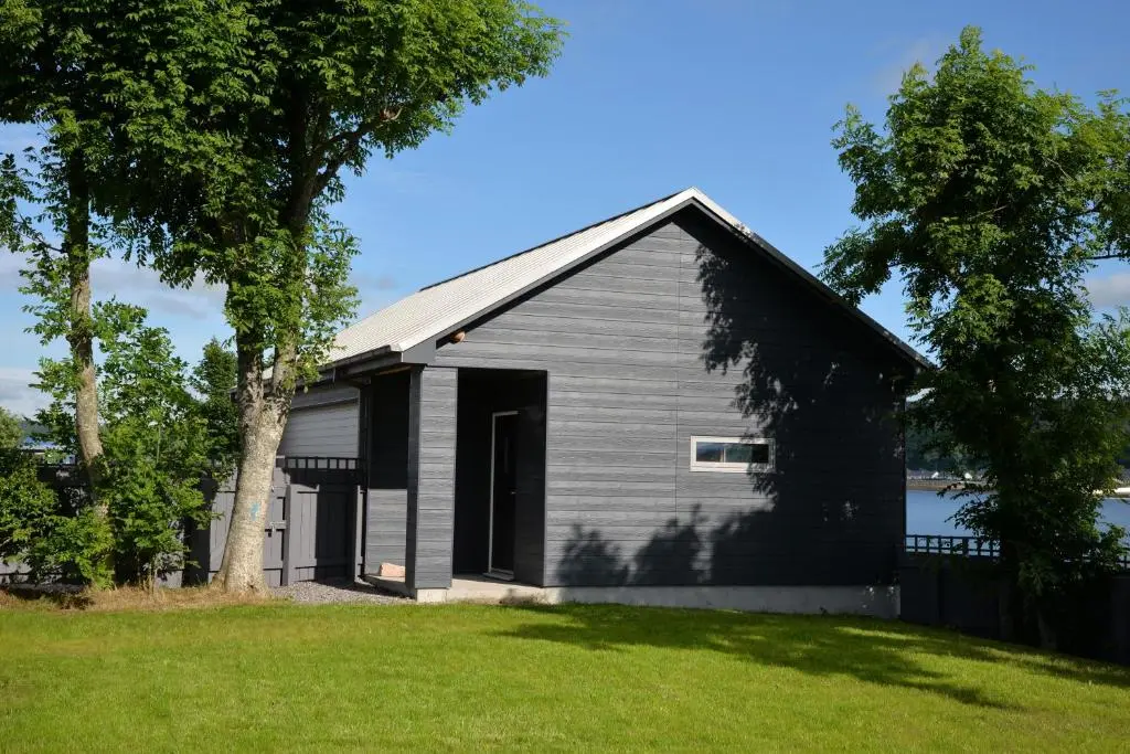 a black house with a tree in a yard at Tangle Tower in Inverness