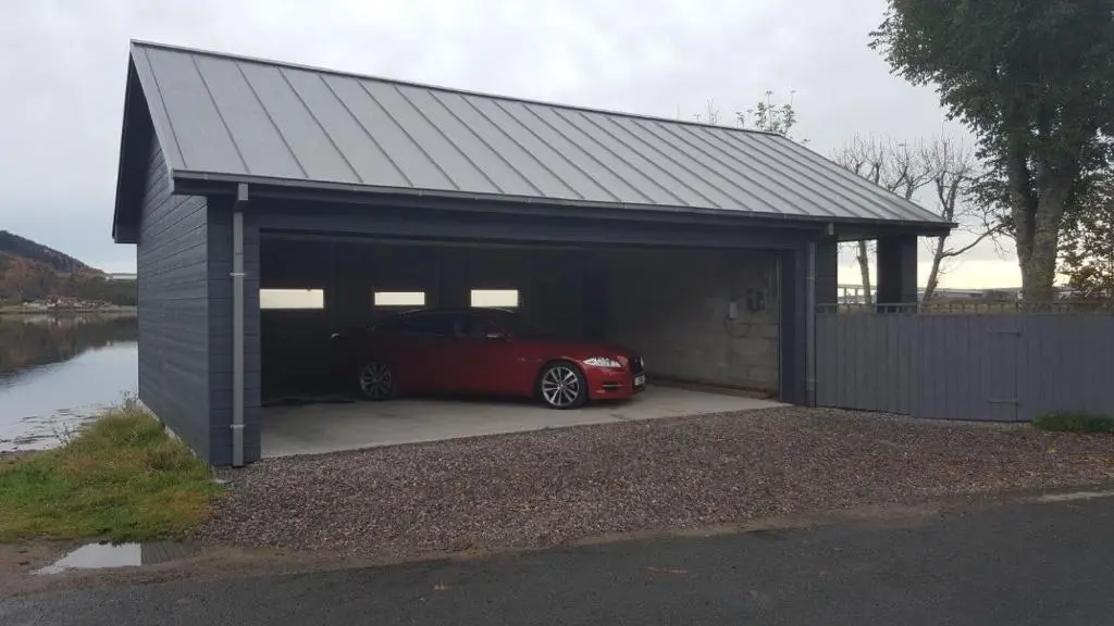 a car in a garage with a red car in it at Tangle Tower in Inverness