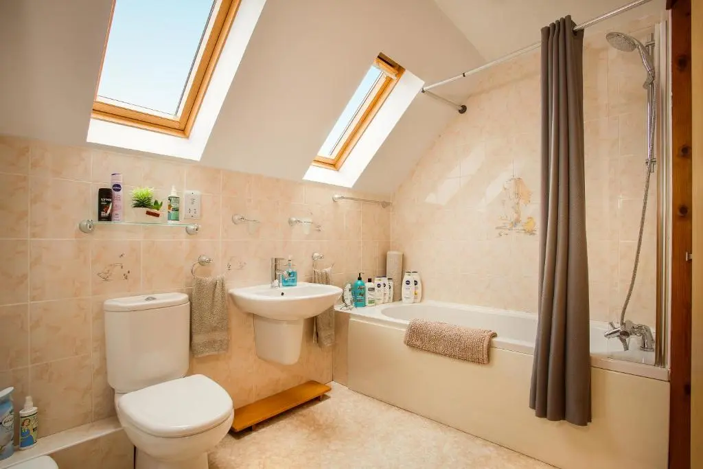 a bathroom with a toilet and a sink and a shower at Beechwood Lodge in Alness