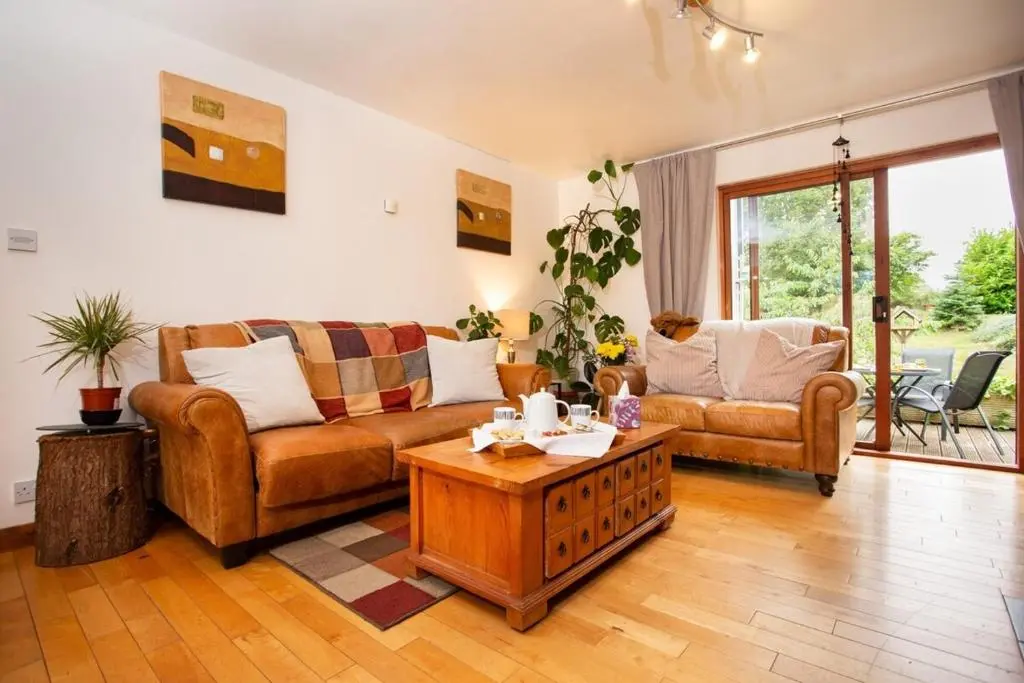 a living room with two couches and a coffee table at Beechwood Lodge in Alness